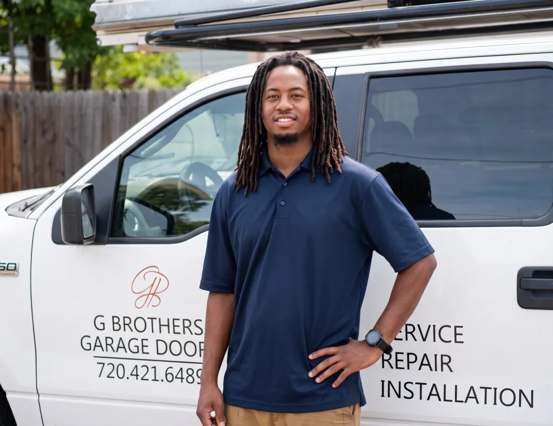 Boddrick Gullatt, owner of G Brothers Garage Doors, standing by a branded service truck